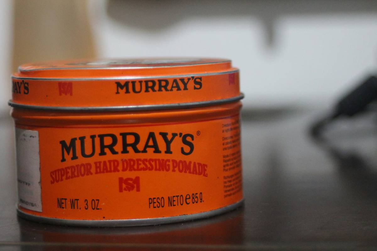 Hand applying hair styling paste to damp hair for natural texture