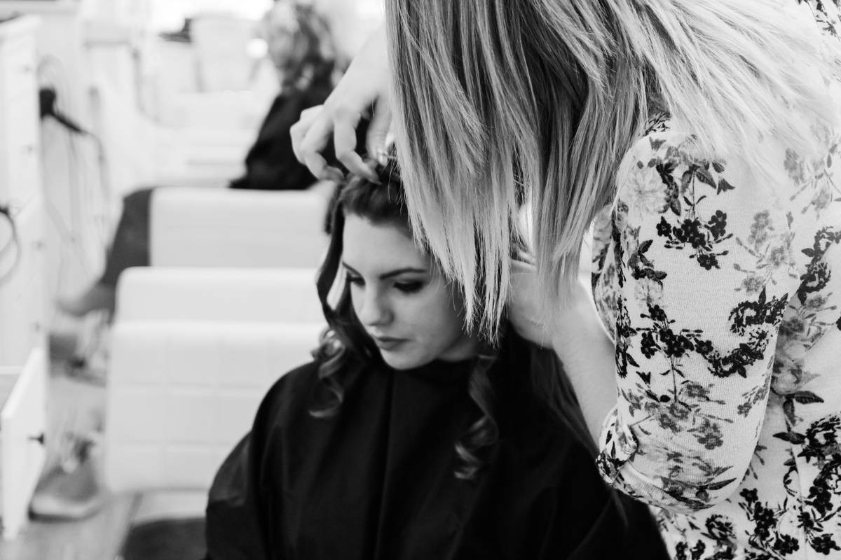 Woman applying hair styling treatment before using a blow dryer