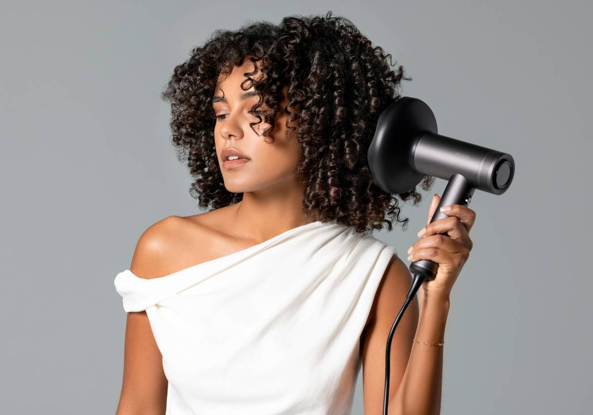 Close-up of a professional salon hair wave iron creating defined waves on dark brown hair